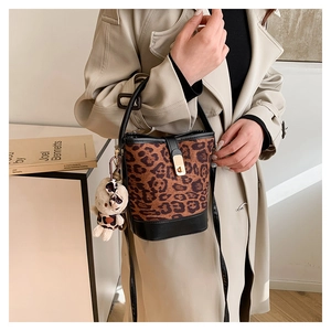 Detail of leopard print bucket bag with gold clasp and cute plush bear charm