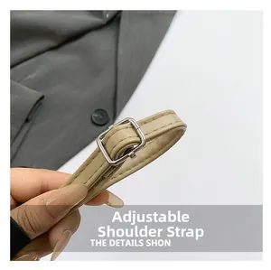 Close-up of adjustable beige leather shoulder strap with a silver metal buckle detail