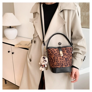 Leopard print bucket bag detail with black leather handle and cute teddy bear charm