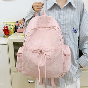 Pink nylon backpack with bow drawstring pocket and large capacity for travel use