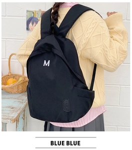 Detail of black student backpack with M print and Tanke logo in a campus setting
