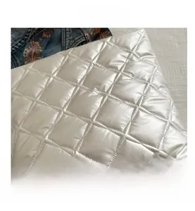 Détail du tissu Oxford blanc matelassé avec motif en losanges et finition brillante