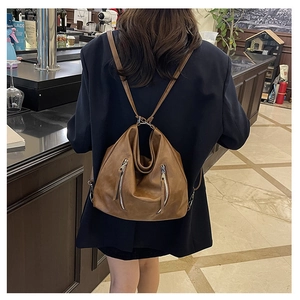 Sac fourre-tout marron vintage en similicuir avec double fermeture éclair porté par un mannequin