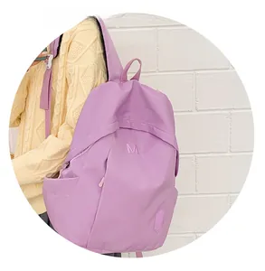 Detail of lavender nylon backpack with purple M embroidery and side zipper pocket