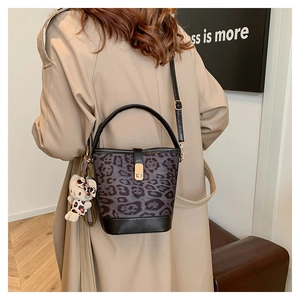 Detailed back view of a stylish leopard print bucket bag on a model wearing a beige trench coat