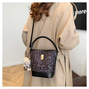 Detail of leopard print bucket bag with black leather handle and Hello Kitty charm