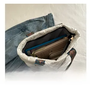Sac fourre-tout matelassé blanc montrant un grand espace pour tablettes et livres
