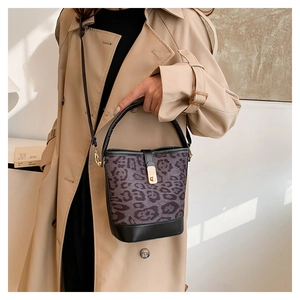 Detailed view of leopard print bucket bag with gold metal clasp and black leather handle