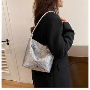 Close-up of silver crocodile embossed tote bag with metallic shine and slim straps