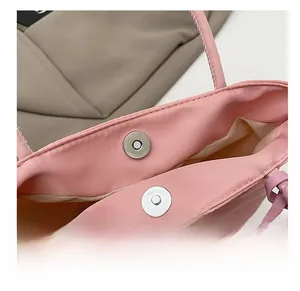 Detail shot of a pink tote bag featuring a strong silver magnetic snap closure