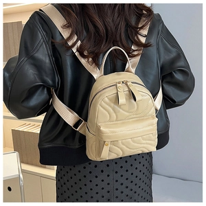 Detail of mini quilted backpack in beige faux leather with adjustable fabric straps