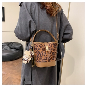 Detailed shot of leopard print bucket bag with leather base and cute bear charm