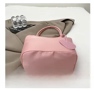 Detail view of the wide bottom design on this stylish pink padded tote with heart charm