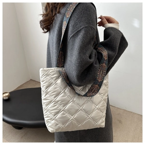 Détail d'un sac cabas blanc matelassé avec une large bandoulière imprimée bohème