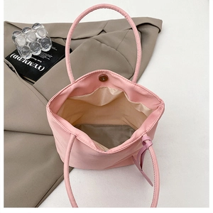 Detailed interior of a pink nylon mini tote bag with magnetic closure and beige lining