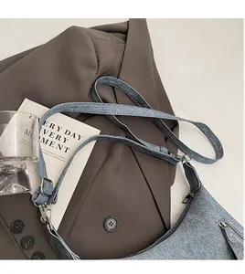 Detail view of grey tote bag showing smooth adjustable long shoulder strap and zipper