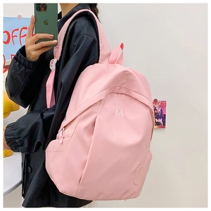 Detailed view of pink high-capacity backpack featuring letter embroidery and side pockets