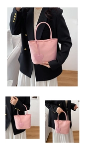 Detailed view of pink nylon mini tote bag with cute heart charm and comfortable handles
