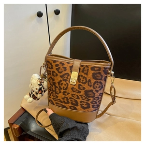 Detail of leopard print bucket bag with gold lock and brown leather trim accents