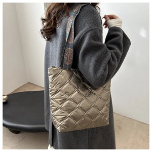 Détail du sac cabas matelassé métallisé bronze avec une bandoulière ethnique colorée
