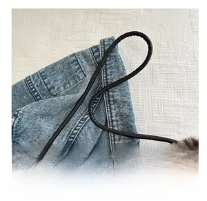 Détail de la bandoulière noire et de la texture en fausse fourrure léopard du sac à main