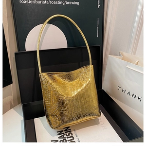 Close-up of golden crocodile pattern bucket bag in premium gift box set