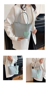 Detail view of light blue nylon mini tote bag with heart charm shown in various scenes