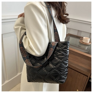 Détail du sac fourre-tout en nylon noir matelassé avec bandoulière ethnique jacquard