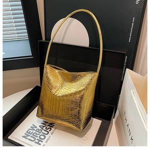 Detail view of gold crocodile pattern handbag featuring glossy metallic texture and texture
