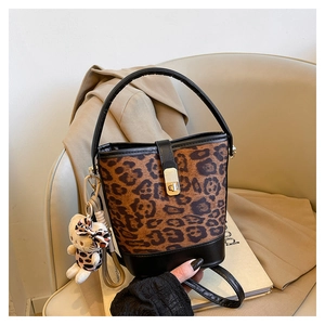 Detail of leopard print bucket bag with golden buckle and textured plush fabric finish