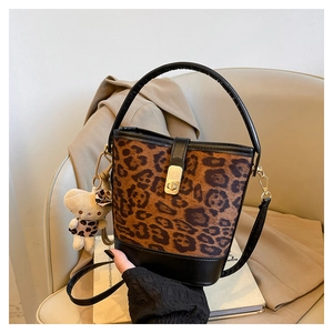 Detail of leopard print bucket bag with gold metal clasp and plush bear charm