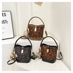 Detailed display of three leopard print bucket bags with metal hardware and bear charms