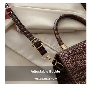 Macro detail of crocodile texture leather bag with metal buckle and shoulder strap