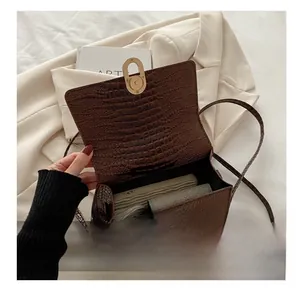 Deep brown crocodile embossed shoulder bag interior view with gold clasp and daily essentials