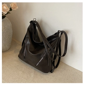 Détail du sac hobo marron café avec doubles fermetures éclair et texture en similicuir
