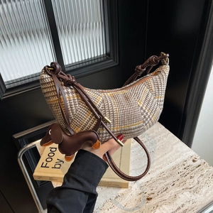 Retro houndstooth crescent bag with brown leather straps and a dachshund charm accessory