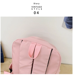 Pink canvas backpack detail showing adjustable shoulder straps and top handle construction