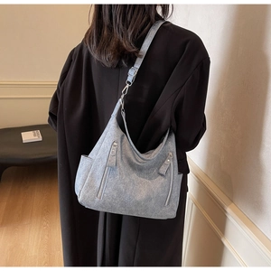 Detail of grey matte tote bag with dual vertical zippers and adjustable shoulder strap