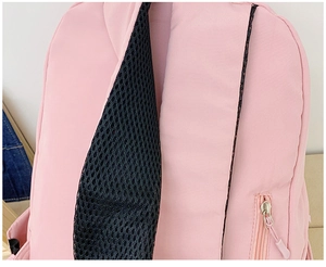 Close-up of breathable mesh shoulder strap and hidden safety zipper pocket on pink backpack