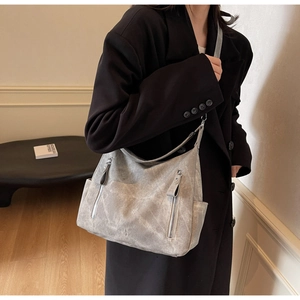 Detail of vintage gray large tote bag with metallic zipper pockets and matte texture