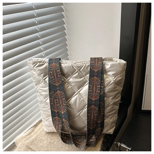 Détail du sac cabas matelassé argenté avec une large bandoulière à imprimé bohème