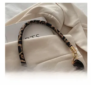 Detailed close-up of leopard print leather handle with luxury gold metallic ring hardware