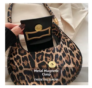 Detail of leopard print crescent bag showing magnetic buckle and premium texture