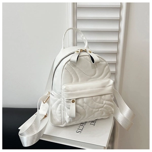 Macro shot of white quilted mini backpack with glossy leather and metallic zippers