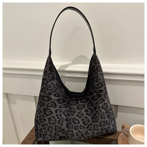 Close-up of leopard print suede tote bag placed on a wooden table with a coffee cup