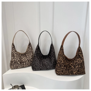 Three stylish leopard print suede tote bags in beige, grey, and brown on display