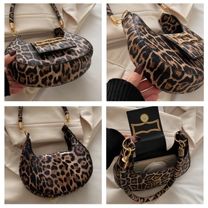Detail view of leopard print crescent bag showing golden hardware and inner compartment