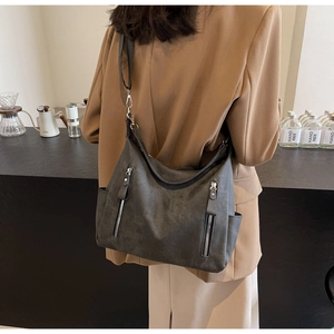 Detail of dark grey hobo bag showing matte leather texture and silver hardware details