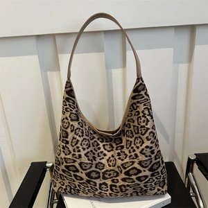 Chic leopard print suede tote bag with brown leather shoulder strap in minimalist setting
