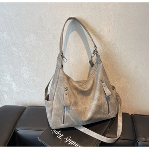 Close-up of vintage grey tote bag with matte texture, multi-pockets, and dual strap detail